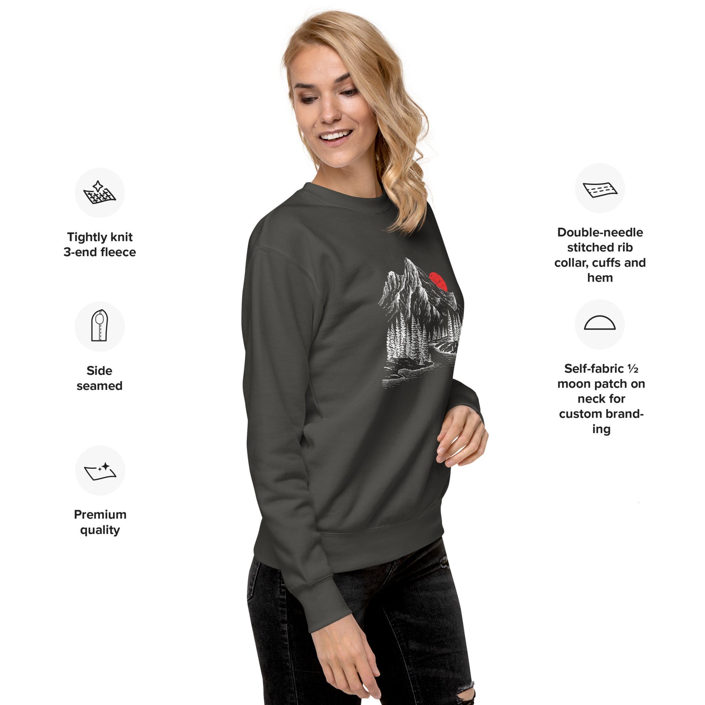 Woman wearing a dark gray sweatshirt with a mountain sketch forest graphic, surrounded by text detailing sweatshirt features.