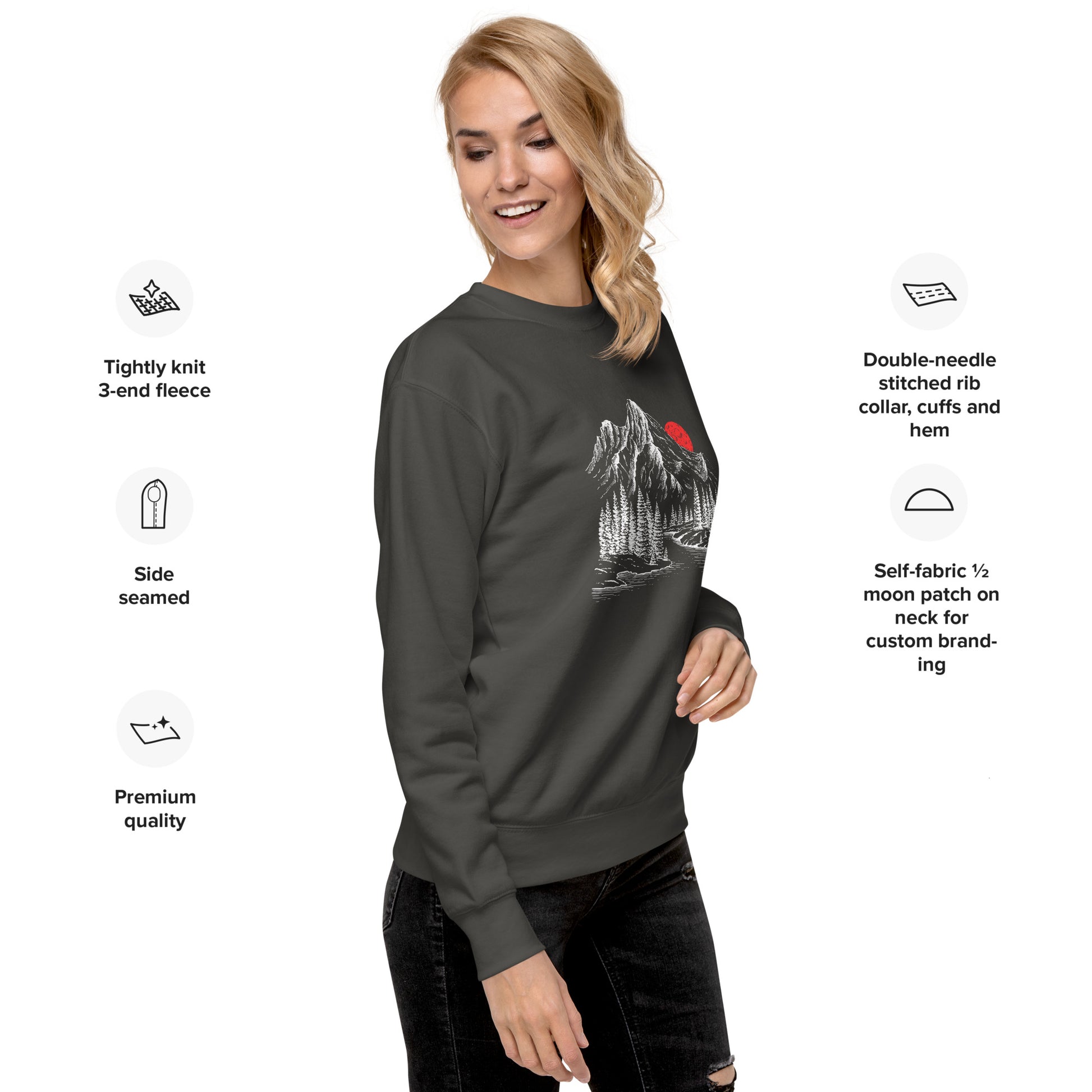 Woman wearing a dark gray sweatshirt with a mountain sketch forest graphic, surrounded by text detailing sweatshirt features.