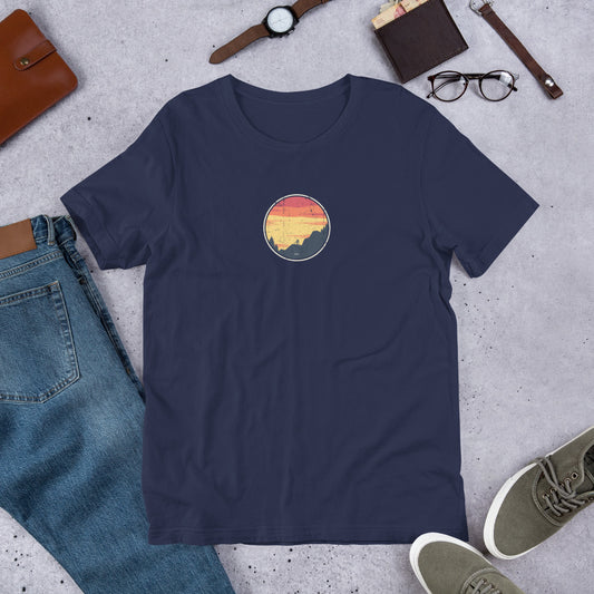 Dark blue t-shirt with vintage mountain bike design on grey surface with jeans, shoes and accessories.