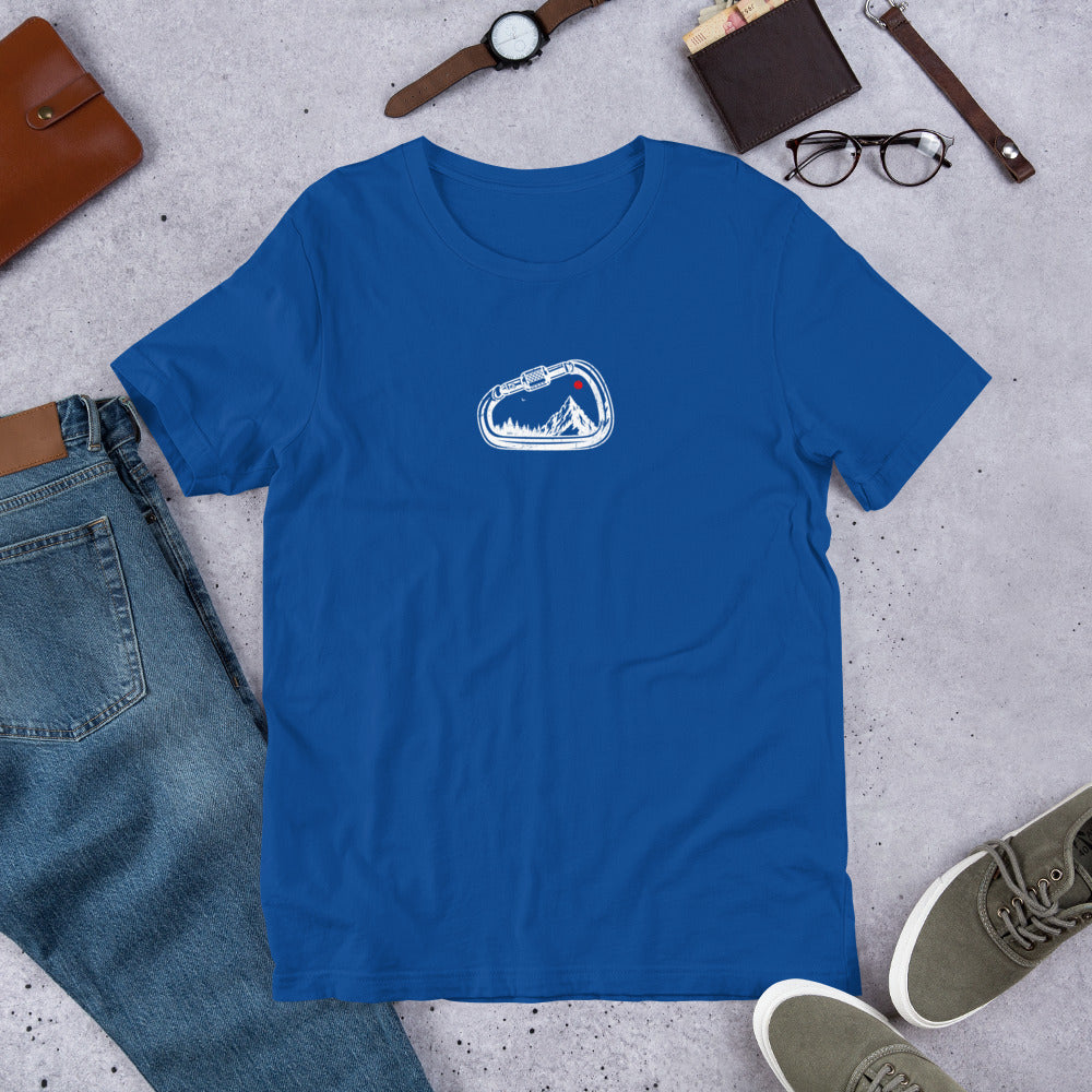 Blue t-shirt with a white logo on a gray surface with jeans, shoes, and accessories.